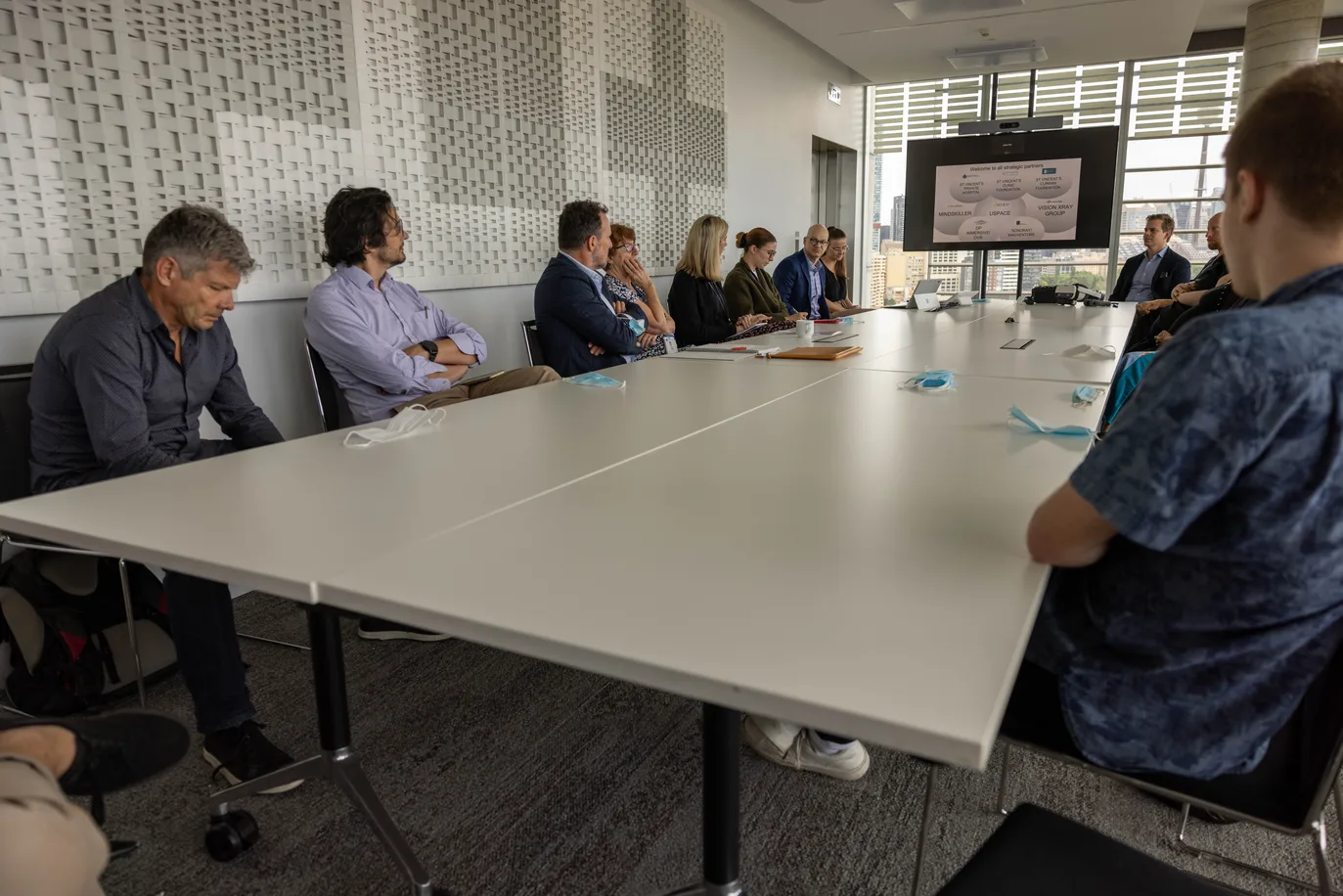 A multidisciplinary care team meeting around a boardroom table.