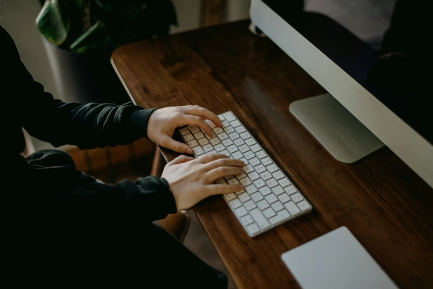 Someone typing on a keyboard at a desk